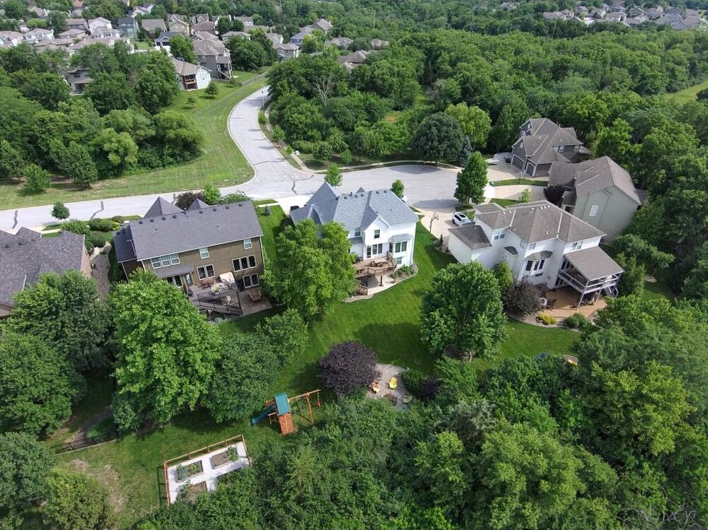 Aerial view of a residential neighborhood surrounded by greenery